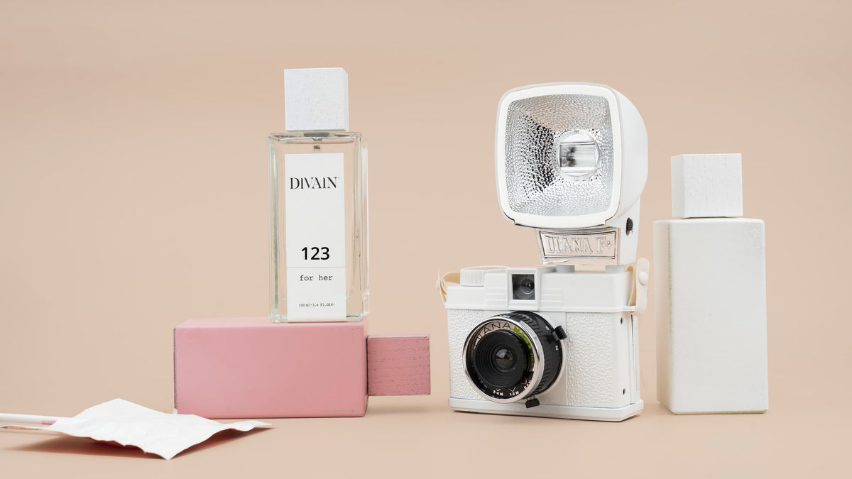 Perfumes equivalentes divain junto a una cámara de fotos antigua