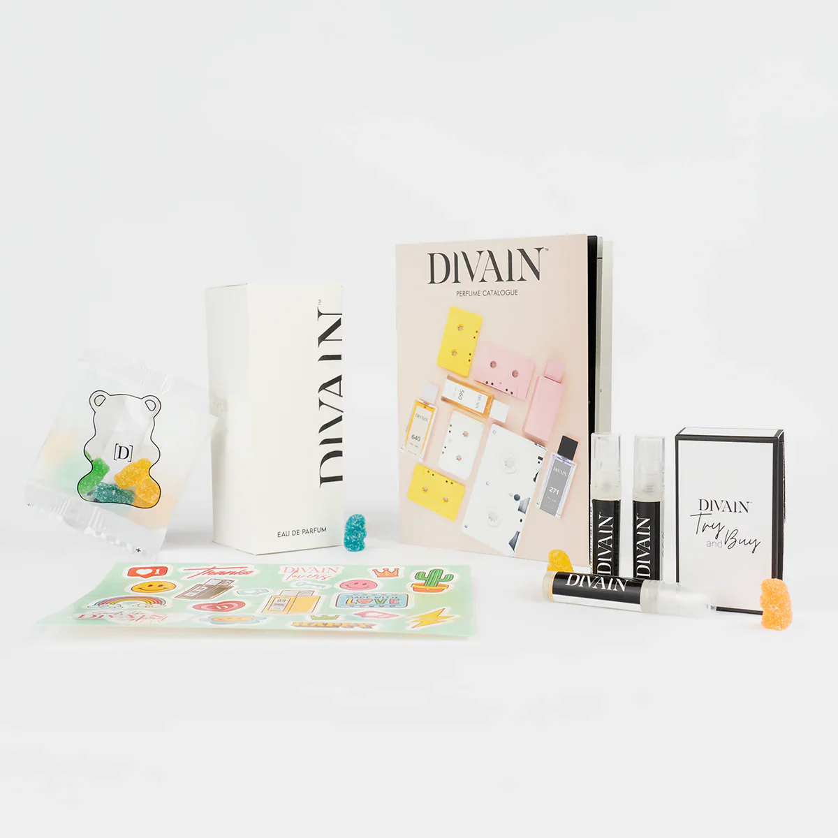 Opened divain package containing divain-970 perfume, stickers, and gummy candies
