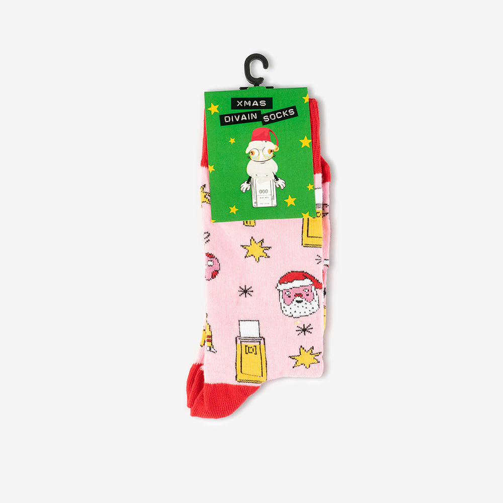 Pink and red socks with Santa Claus drawings and divain perfume with a green brand label.