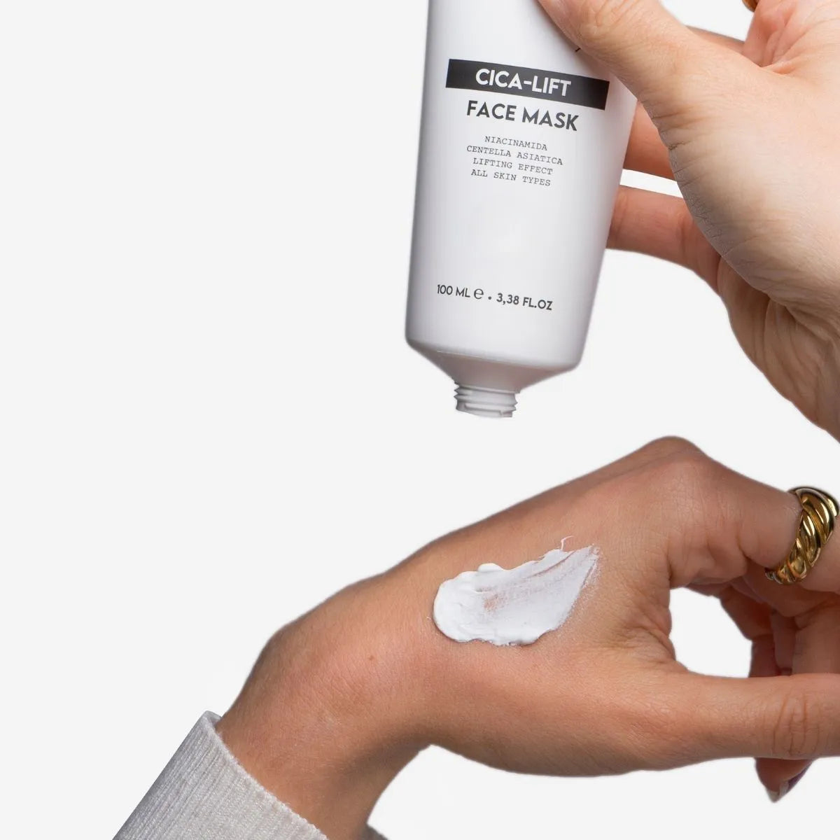 Mascarilla facial divain Care cica-lift aplicada en la piel de la mano