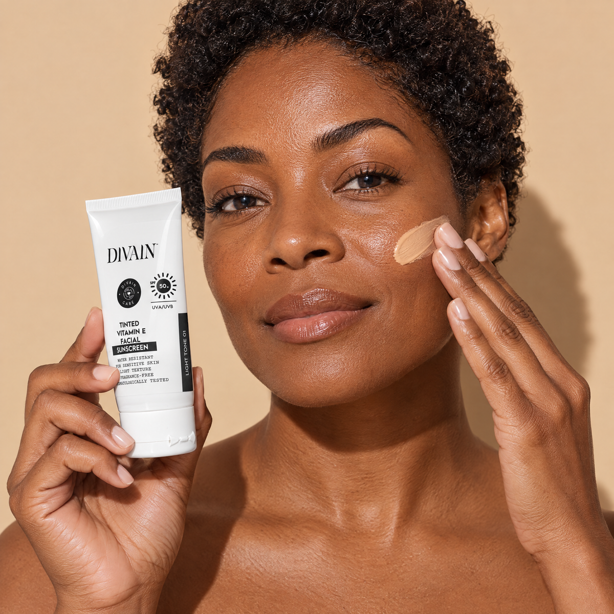 Persona usando divain. Care Tinted Vitamin E Sunscreen SPF50+ Light Tone 01