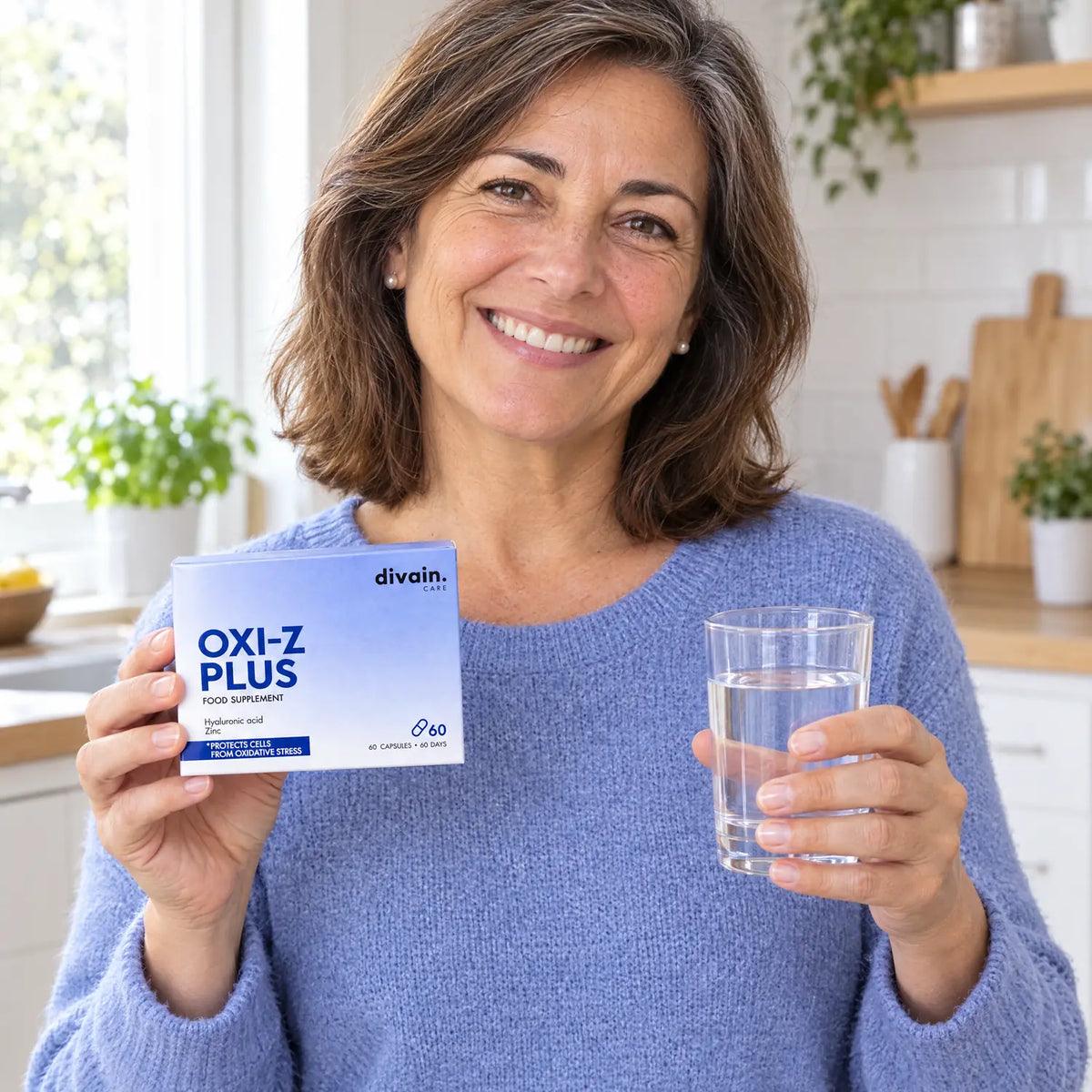 Mujer en su cocina con OXI-Z PLUS y un vaso de agua