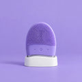 Masajeador limpiador facial divain. Care lila en su soporte