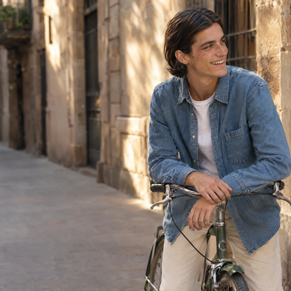 Chico con bicicleta en una calle de Barcelona