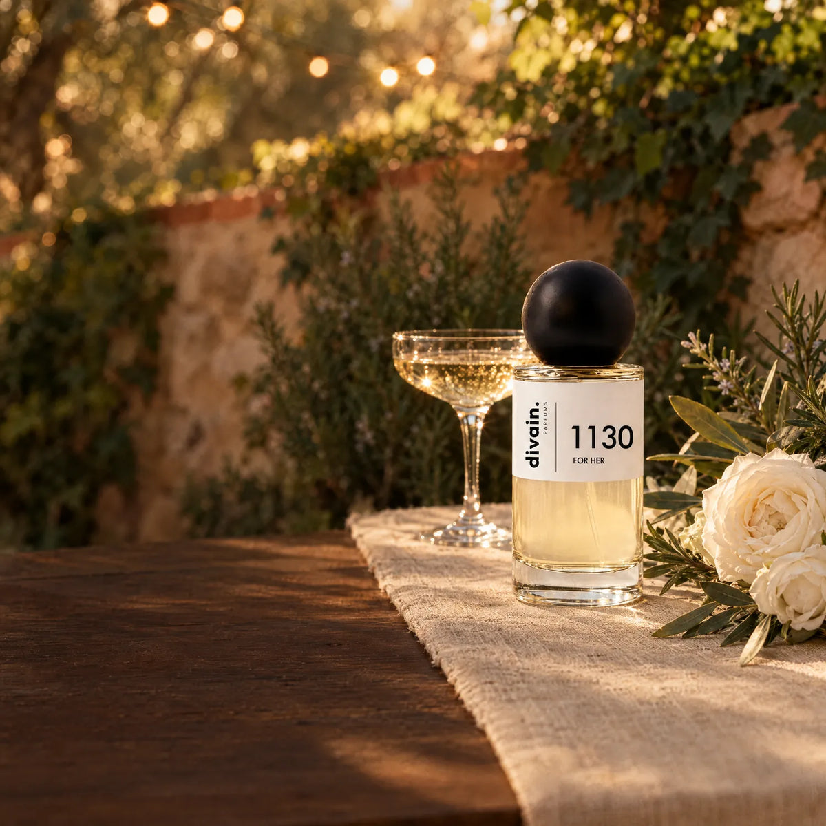 Perfume divain. 1130 en una mesa de boda en un jardín al atardecer