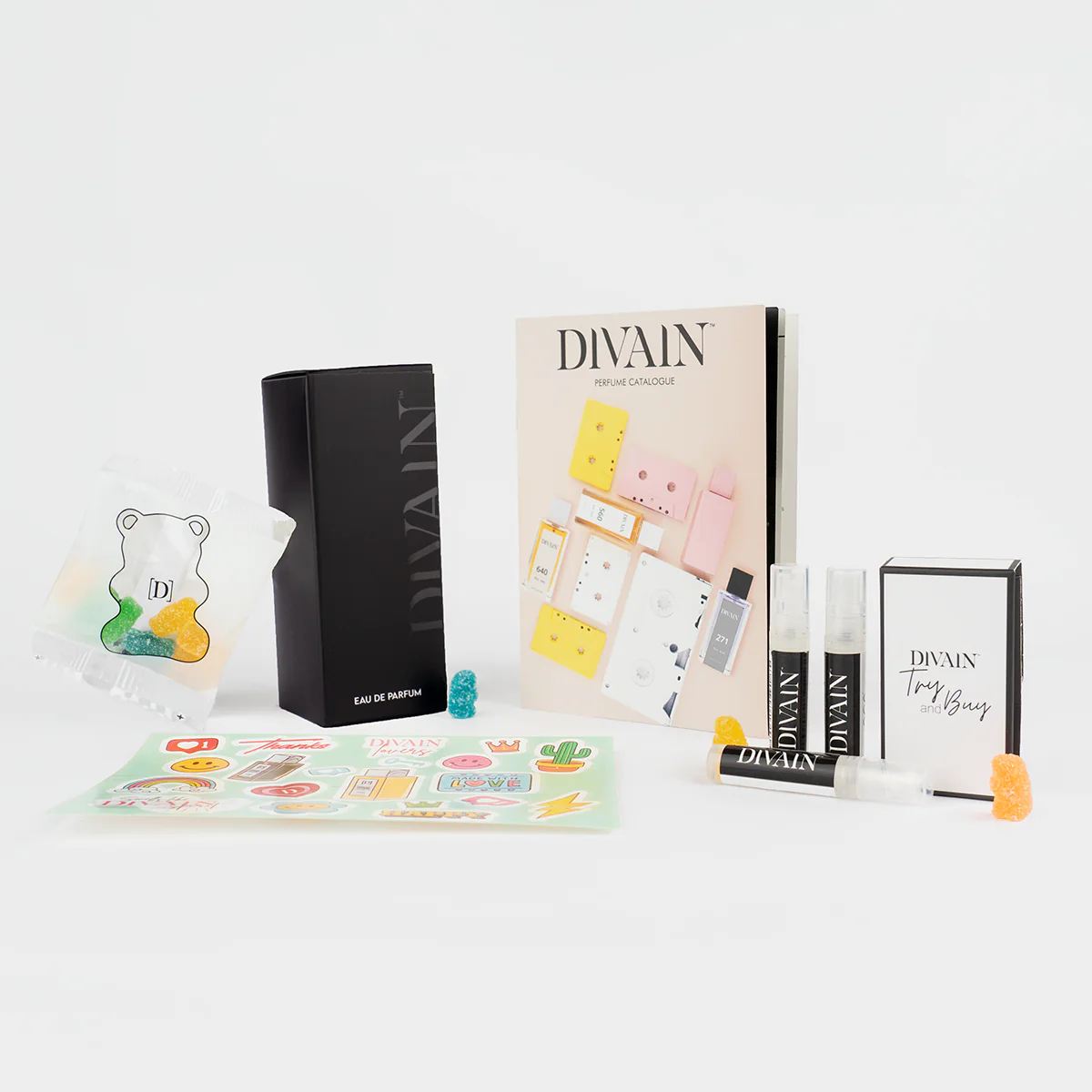 Opened divain package containing divain-462 perfume, stickers, and gummy candies
