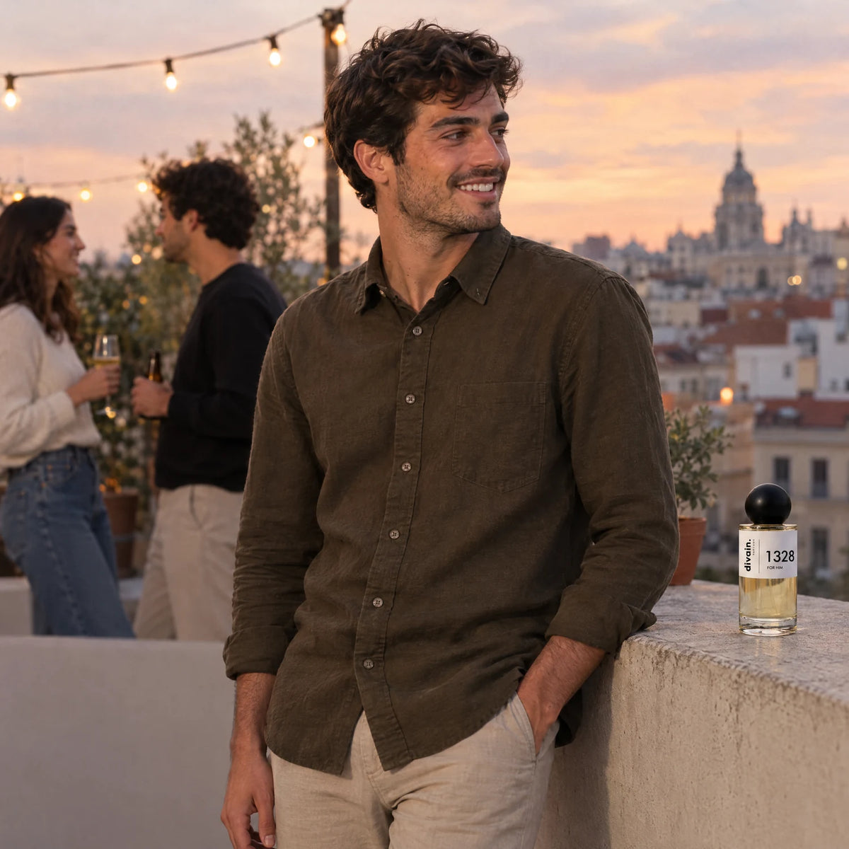 Hombre joven en una fiesta en azotea al atardecer con divain. 1328 en el muro