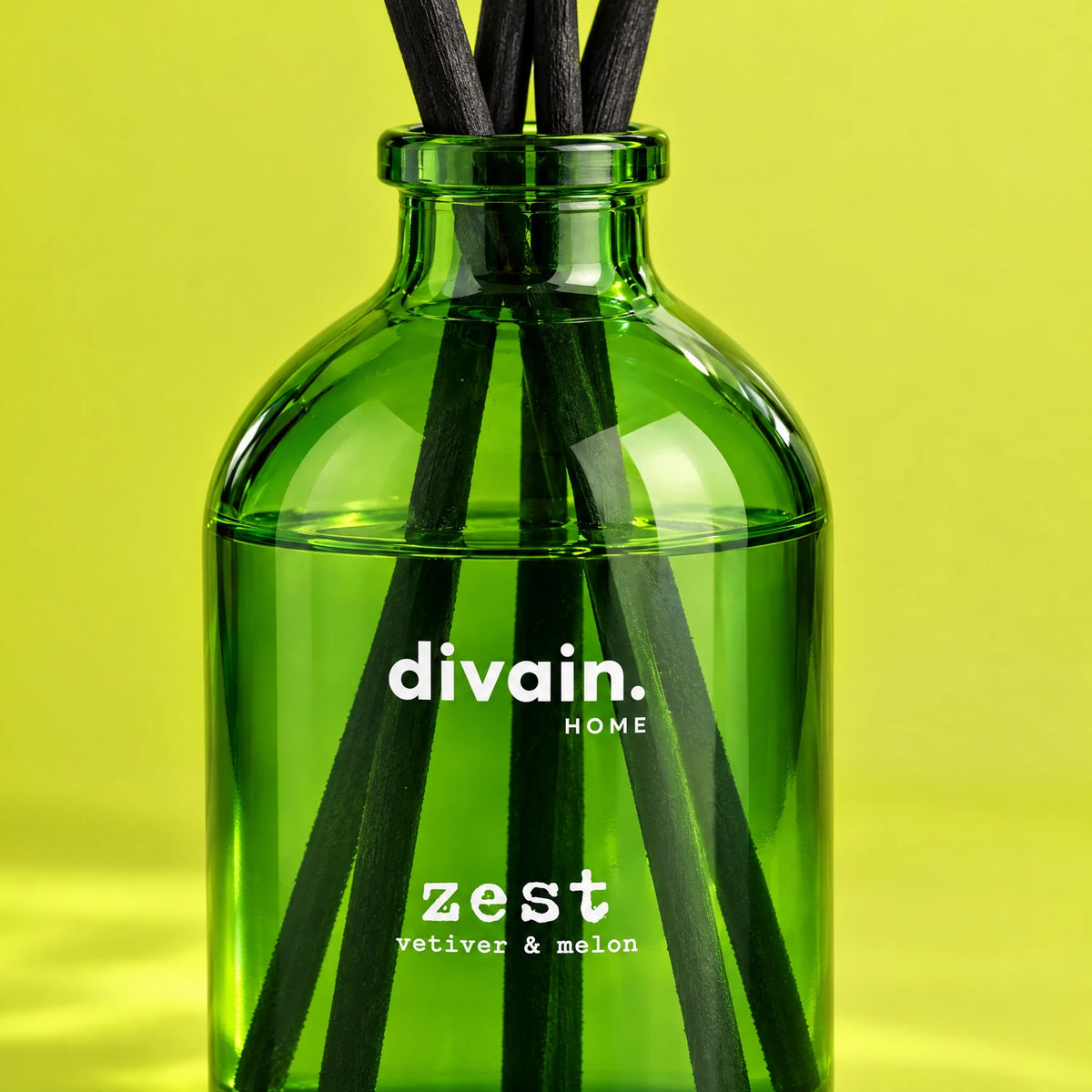 Detalle del frasco de vidrio verde y las varillas del mikado Zest