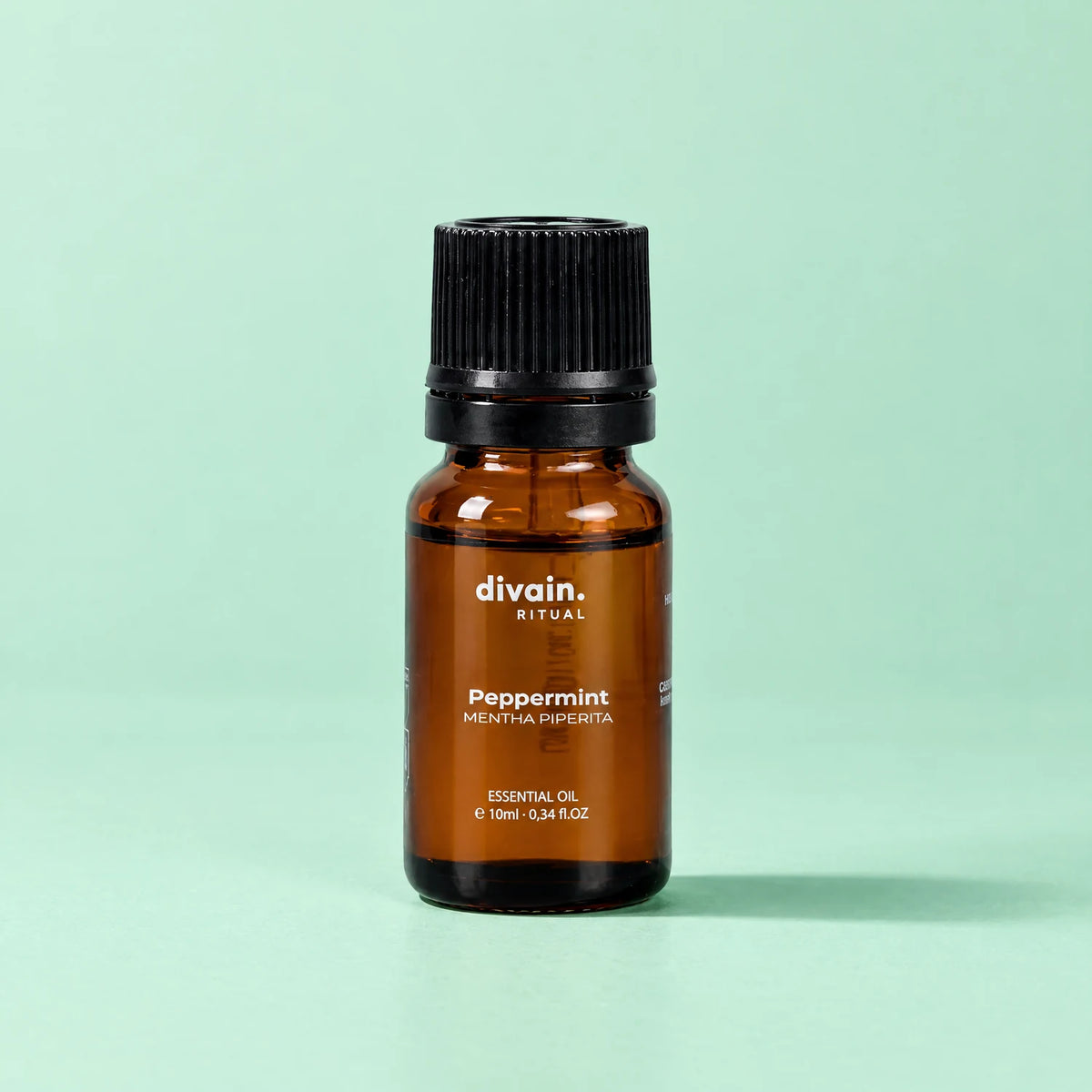 Aceite esencial de menta piperita divain. RITUAL 10 ml sobre fondo verde menta