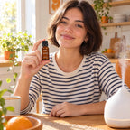 Mujer joven en su cocina con el aceite esencial de naranja dulce