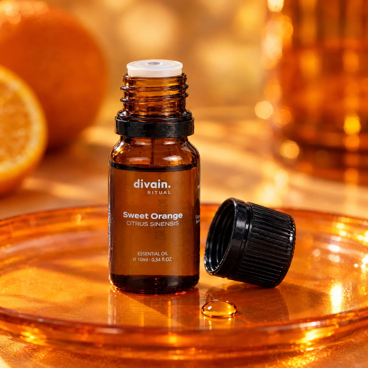 Frasco abierto con cuentagotas y una gota de aceite de naranja dulce