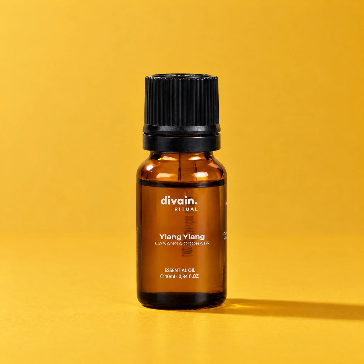 Aceite esencial de ylang ylang divain. RITUAL 10 ml sobre fondo amarillo dorado