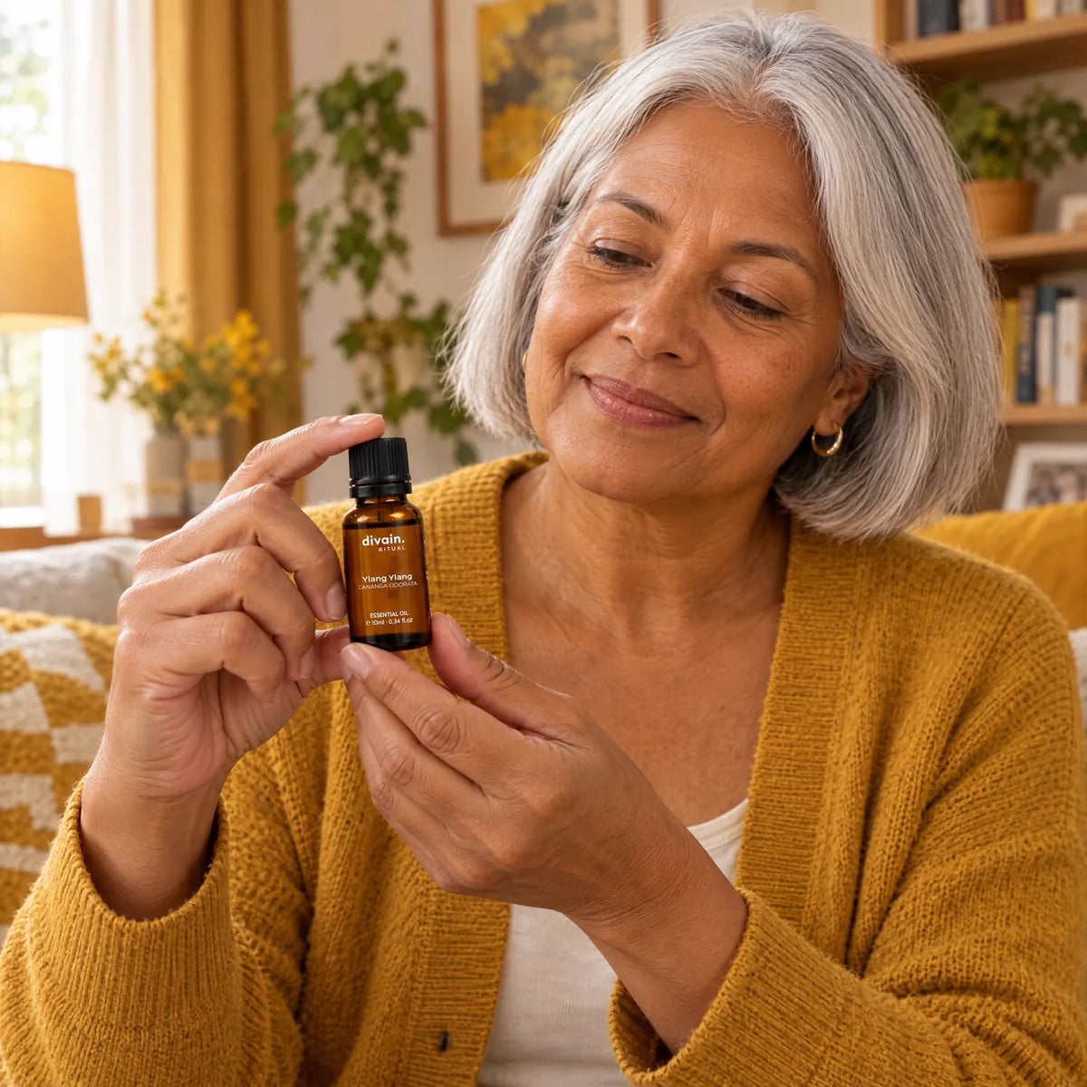Mujer de 60 años en su salón con el aceite esencial de ylang ylang