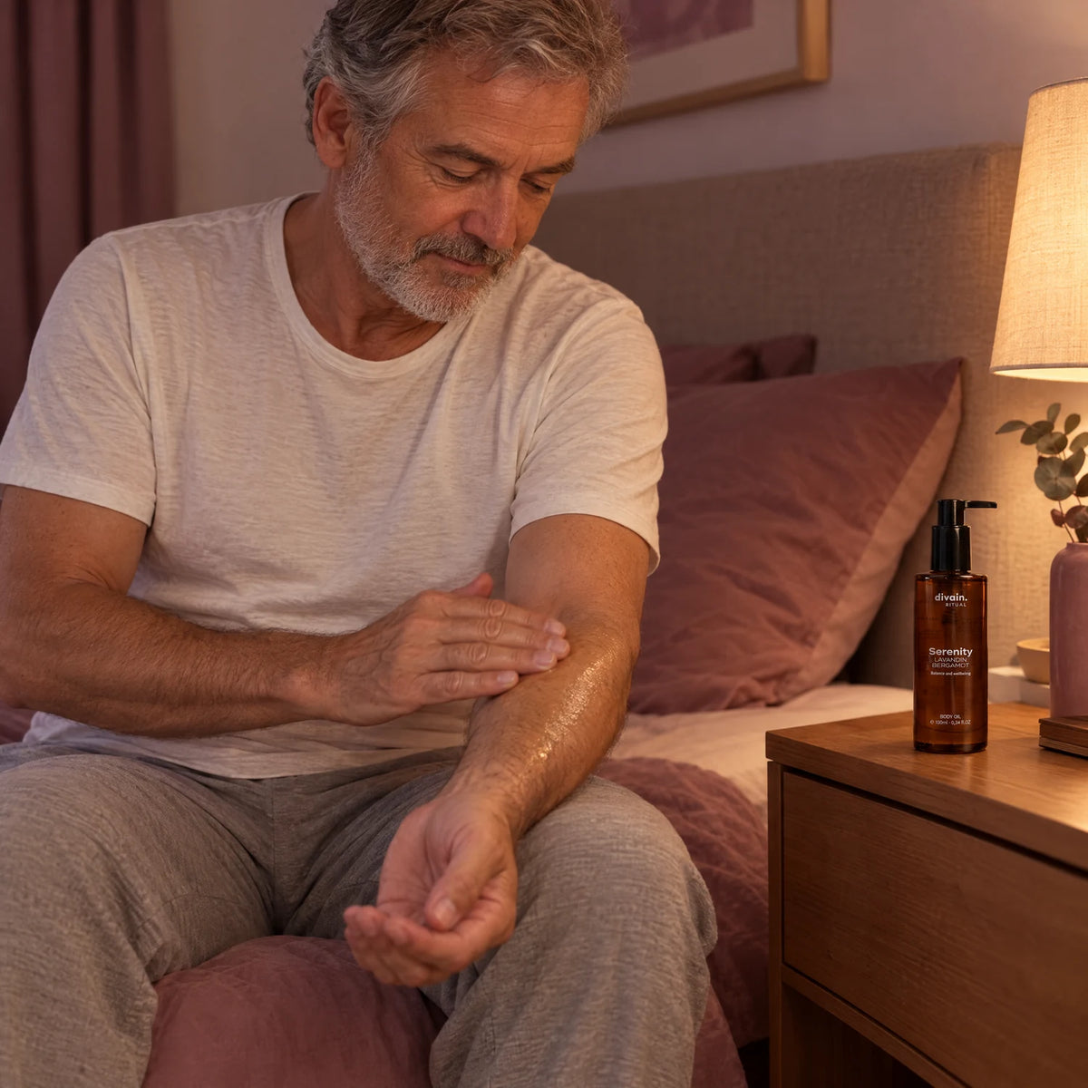 Hombre de 60 años aplicándose Serenity Body Oil en el brazo antes de dormir