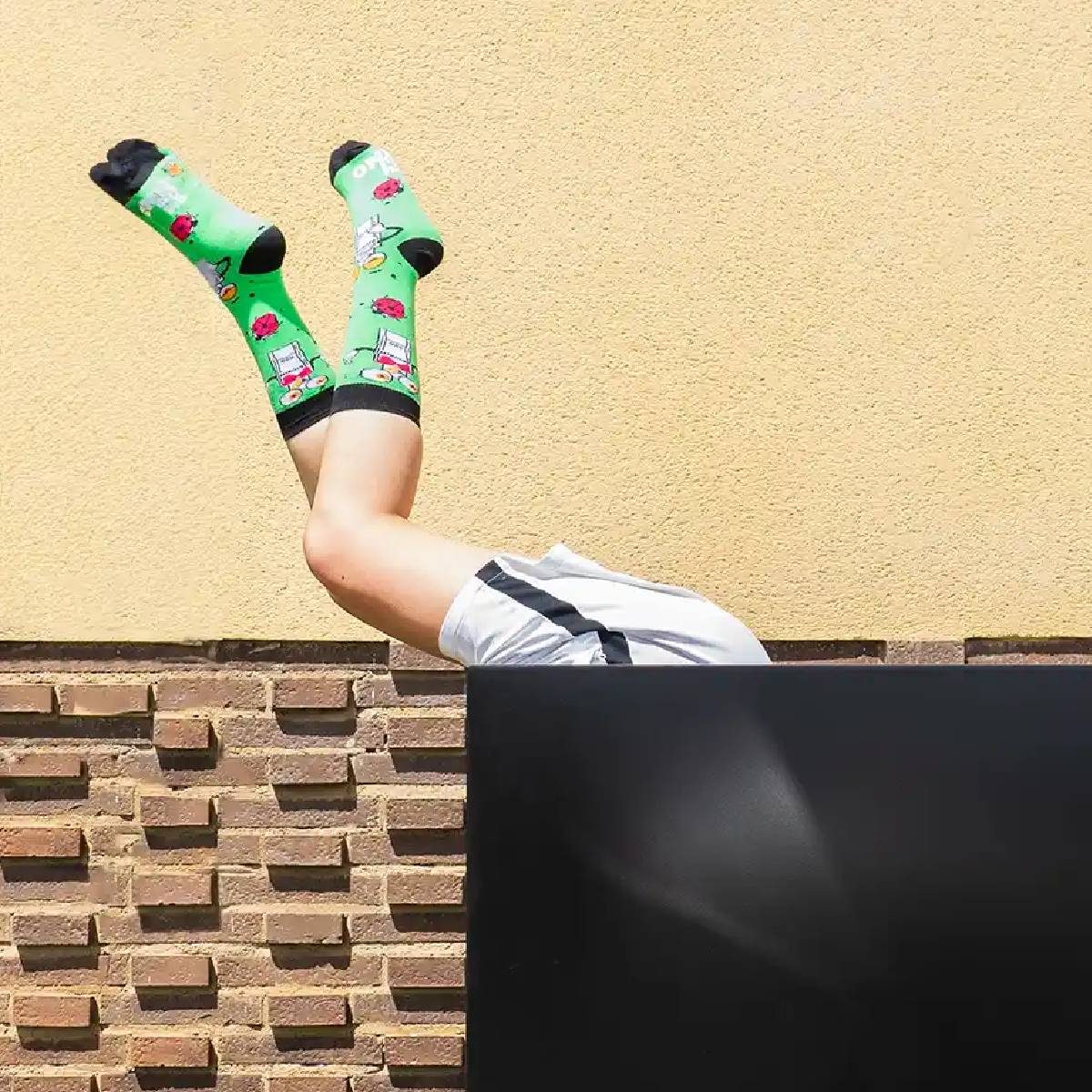 Caja negra y dentro una modelo sacando las piernas por encima y viendose los calcetines