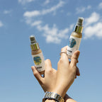 Body mist Hawaii e Ibiza mostrandose en las manos sobre un fondo de un cielo azul.