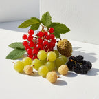 Grosella, lichi y sauco representando las notas olfativas del perfume.