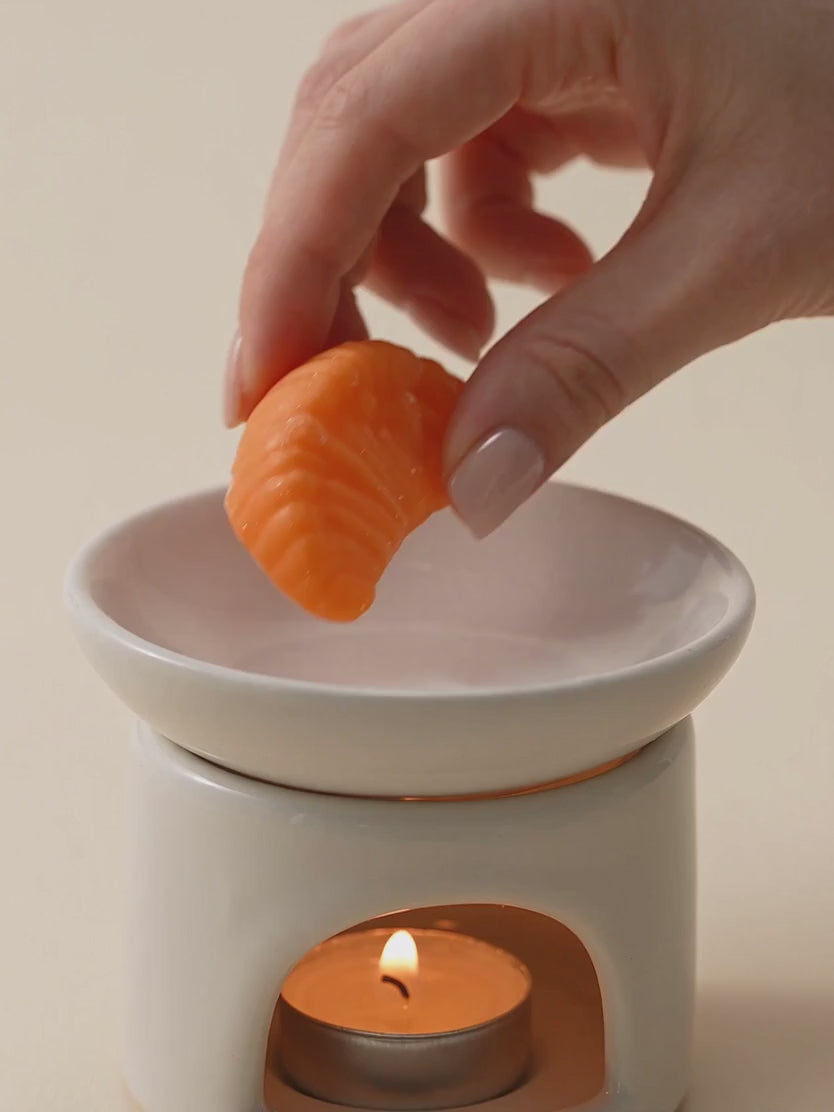 Wax melts Citrus de divain.: cubo con la d. y gajo de mandarina de cera derritiéndose en el quemador