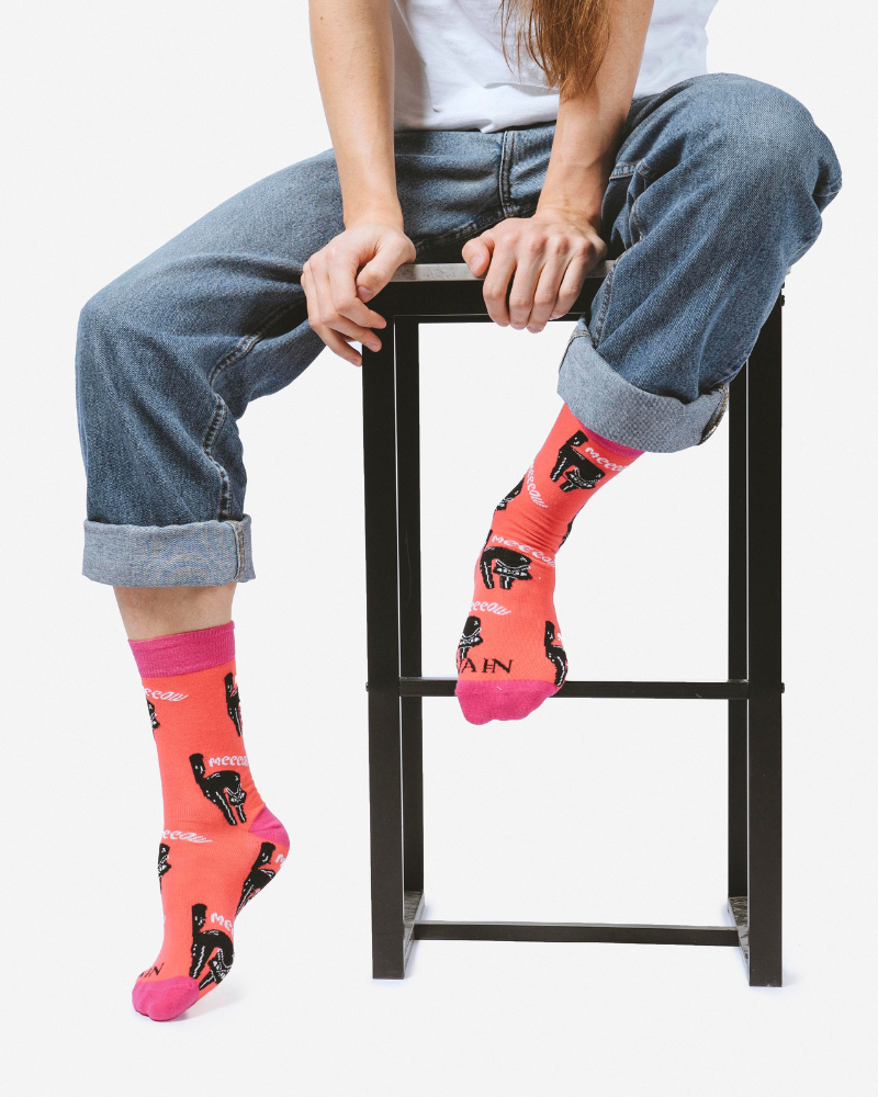 Model seated in a high chair with leggings on 